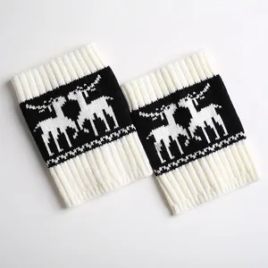 Detailed view of knitted Christmas leg warmers with white reindeer jacquard on black base