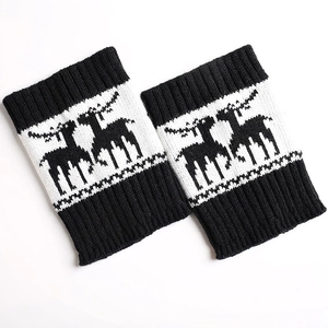 Close-up of knit leg warmers with black and white reindeer patterns for Christmas