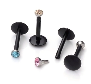 Macro view of black flat-back lip studs with colorful zircon stones in various colors