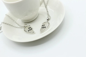 Detail view of heart-shaped split necklaces with rhinestones and Best Friends engraving