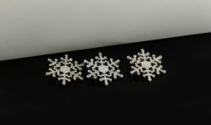 Detailed view of rhinestone encrusted snowflake brooches in gold and silver metal finishes