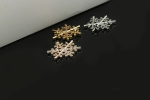 Detail view of snowflake brooches showing back pin fastening and metal finish