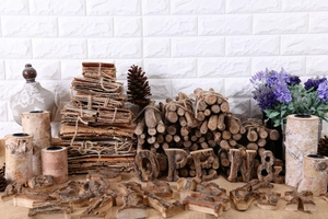 Detail of rustic birch wood bark letters and natural log candle holders on burlap surface