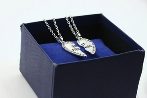 Macro detail of silver heart pendants with rhinestones in a blue jewelry gift box