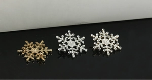 Detailed view of rhinestone snowflake brooch with gold and silver plating and safety pin back