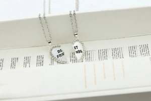 Detail of silver heart-shaped split necklaces with Best Friends engraving and crystals