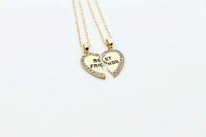 Detail of gold heart puzzle necklaces with rhinestones and Best Friends engraving