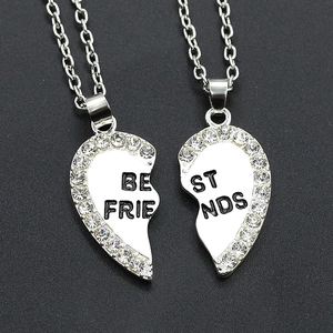 Silver split heart Best Friends necklace set with rhinestones on a dark background