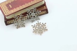 Detailed view of silver and gold snowflake brooches with rhinestones on vintage book