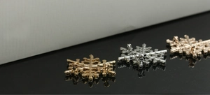 Close-up of sparkling rhinestone snowflake brooches with secure safety pin backings