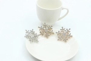 Macro detail of sparkling rhinestone snowflake brooches in gold and silver plating
