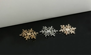 Macro view of crystal snowflake brooches showing back pin mechanism in gold and silver