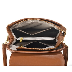 Internal view of brown leather handbag featuring multiple compartments and herringbone lining