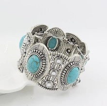 Macro shot of bohemian wide bracelet with oval turquoise stones in silver setting