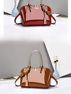 Close-up of shell-shaped patent leather handbags with glossy finish and gold hardware