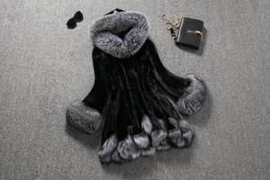 Detailed view of black faux fur coat with thick grey fur trim on hood and cuffs