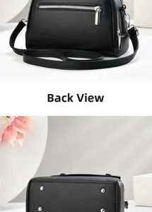 Detail view of black lychee leather crossbody bag with rear zipper and bottom metal studs