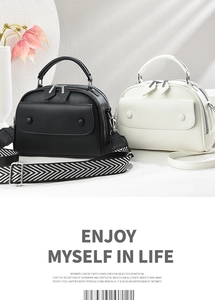 Detail of lychee pattern leather shoulder bags in black and white with wide striped strap