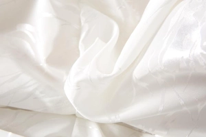 Macro shot of white faux fur texture with elegant jacquard patterns and silky luster