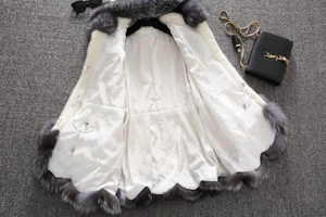 Close-up of faux fur coat lining and collar detail with elegant chain bag accessory
