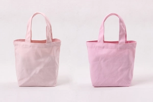 Detail view of pink canvas lunch bags showing fabric texture and sturdy carry handles
