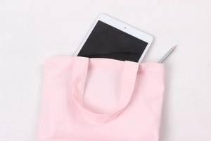 Pink canvas lunch bag holding a tablet and pencil for daily office commute use