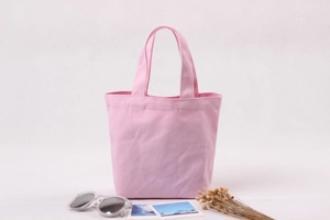 Detailed texture of pink canvas lunch bag with dual handles and open-top design