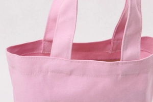 Detail view of pink canvas tote bag showing reinforced stitching and fabric texture