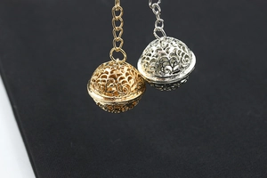 Macro shot of gold and silver hollow sphere pendants with intricate mesh patterns