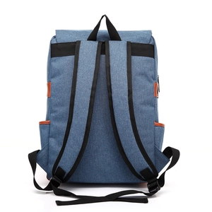Back view of blue denim travel backpack with brown leather details and black straps