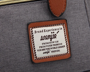 Detailed macro shot of vintage canvas backpack with brown leather patch and stitching
