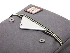Detail of vintage canvas backpack with metal zipper, magnetic buckles and leather tag