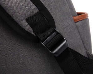 Detail of adjustable gray canvas shoulder strap with black buckle and brown leather trim