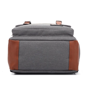 Detailed close-up of gray canvas and brown leather bottom stitching on outdoor backpack