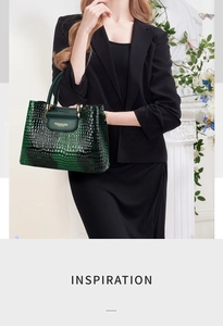 Close-up of dark green crocodile embossed handbag with metal hardware and dual handles