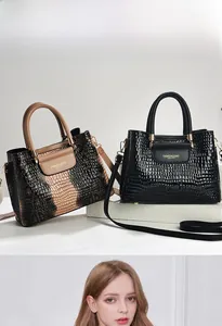 Detailed view of crocodile embossed leather texture with elegant gold brand lettering