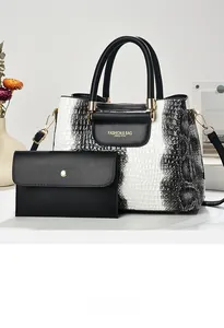 Detailed view of crocodile pattern handbag and matching wallet set with gold hardware