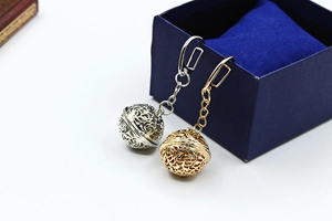 Detailed macro of gold and silver hollowed-out metal ball pendants with intricate floral patterns