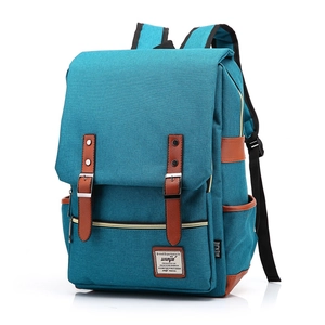 Detail of teal canvas backpack with brown leather straps and metal buckle accents