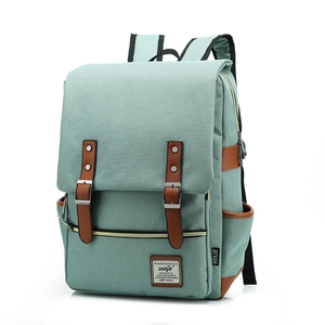 Detail of light green canvas backpack featuring brown leather straps and metal buckles