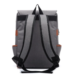 Rear view of grey canvas backpack with black adjustable straps and brown leather side pockets