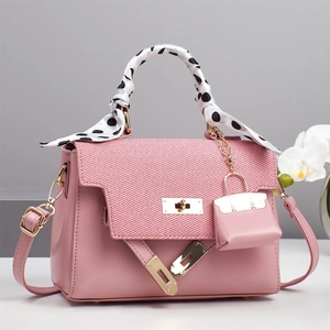 Pink leather handbag with textured flap, polka dot scarf, and gold H-clasp closure