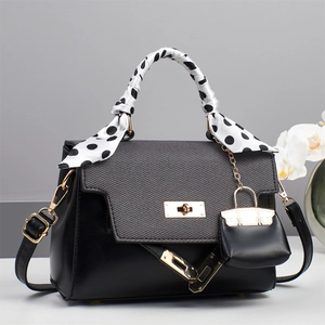 Elegant black leather handbag with grey textured flap and silk scarf handle detail