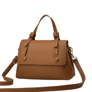 Caramel brown pebbled leather saddle bag with top handle and gold hardware in front view