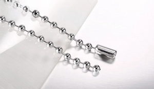 Close-up detail of silver stainless steel ball chain with cylindrical connector link