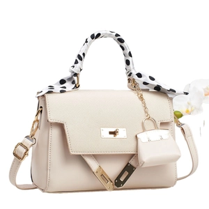 Beige leather and woven handbag with floral accent and polka dot scarf wrap