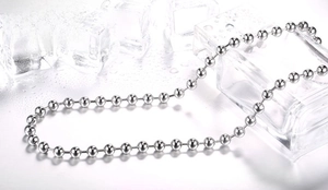 Detailed view of polished stainless steel ball chain necklace against ice and water droplets