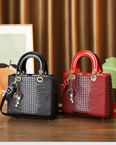 Detailed macro view of crocodile pattern patent leather handbag with golden charms