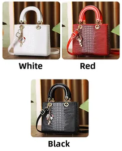 Detail of luxury crocodile texture handbag with shell charms and gold-tone hardware