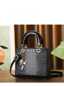 Detail of black crocodile embossed tote bag with nautical shell and starfish metal charms